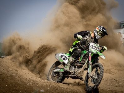 Dynamic motocross racers competing at the SuperMotocross World Championship with a backdrop of a filled grandstand.