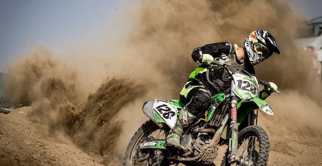 Dynamic motocross racers competing at the SuperMotocross World Championship with a backdrop of a filled grandstand.