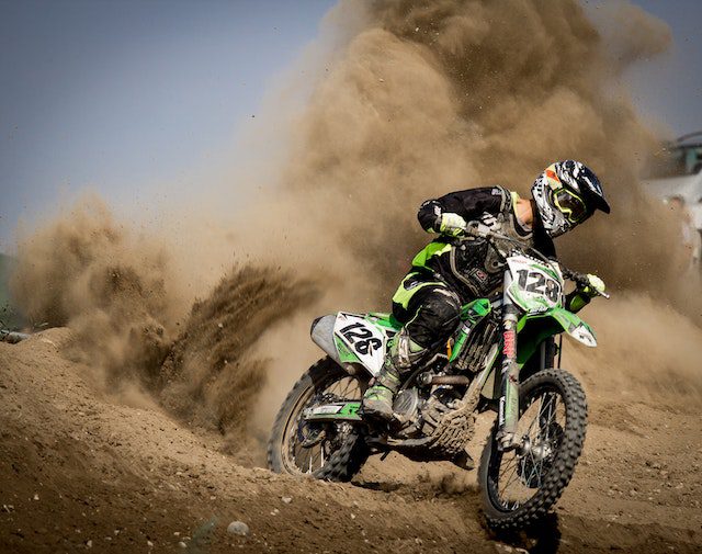 Dynamic motocross racers competing at the SuperMotocross World Championship with a backdrop of a filled grandstand.